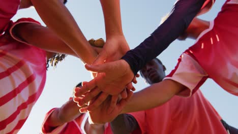 video of diverse group of male football players on field, discussing game tactics