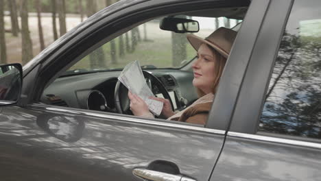 red haired woman is lost with her car in the middle of the countryside