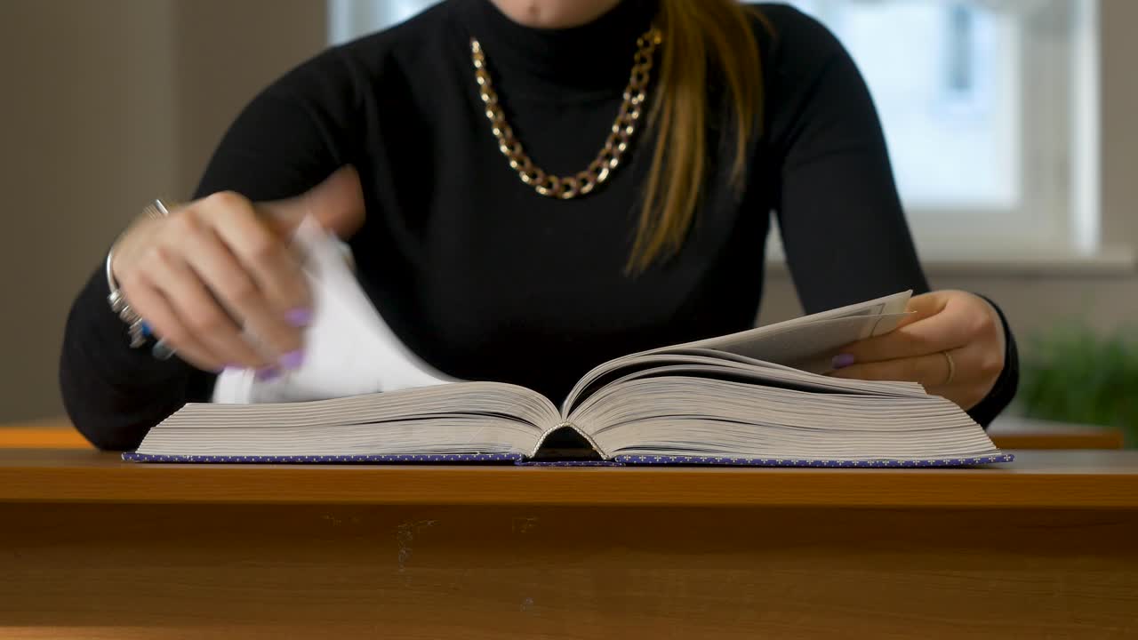 женщина читает книгу за столом