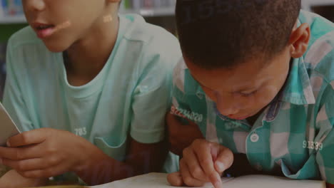 animation of numbers over biracial schoolboys reading in class