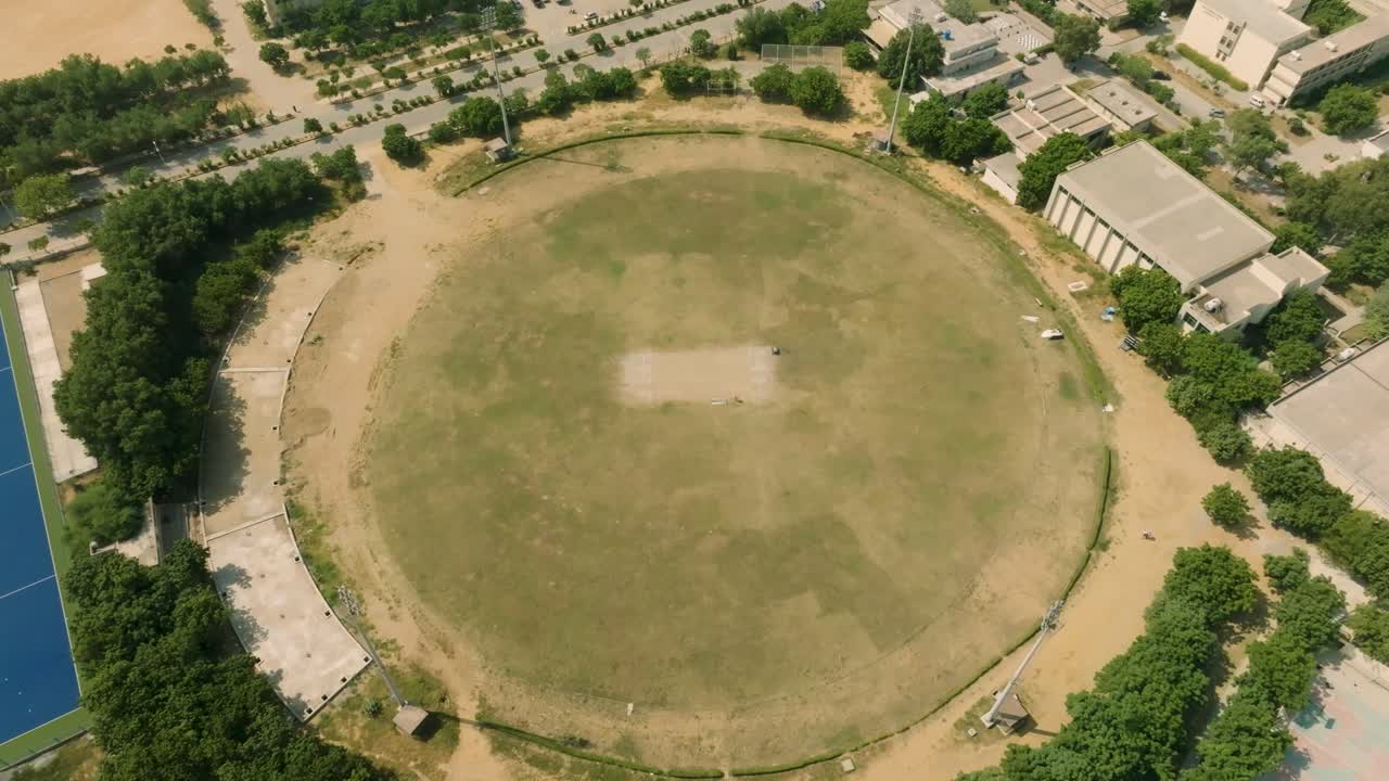 Aerial view of the cricket ground at NED University of Engineering and Technology in Karachi Pakistan showcasing the green field and surrounding buildings