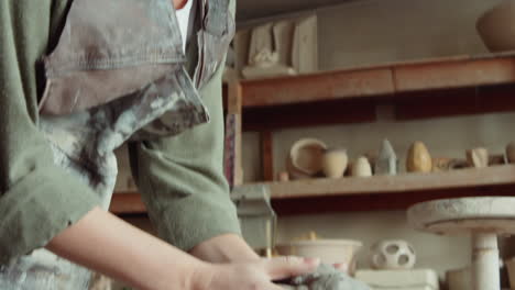 female potter cutting piece of clay with wire