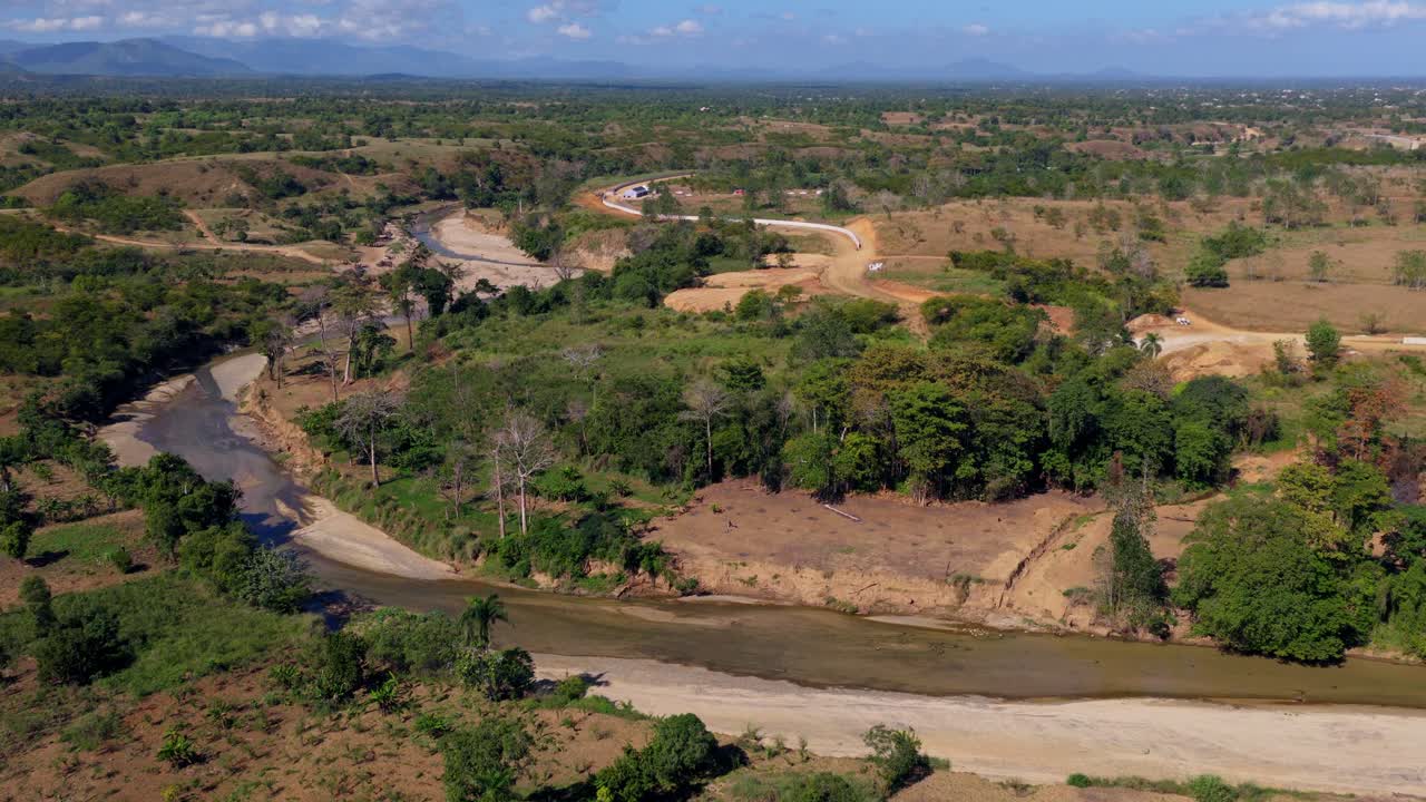 Massacre-floden, der bugter sig gennem de tørre, skovryddede bakker ved grænsen mellem Haiti og Den Dominikanske Republik. Fremadgående luftoptagelse.