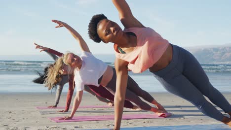 Gruppe-Verschiedener-Freundinnen,-Die-Yoga-Am-Strand-Praktizieren