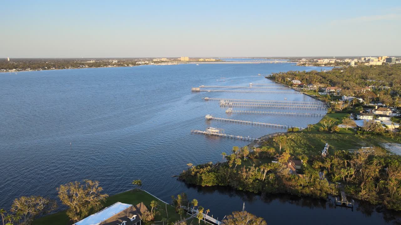 Aerial view of Manatee River with damaged docks, fallen trees, and power restoration efforts. Crane Up