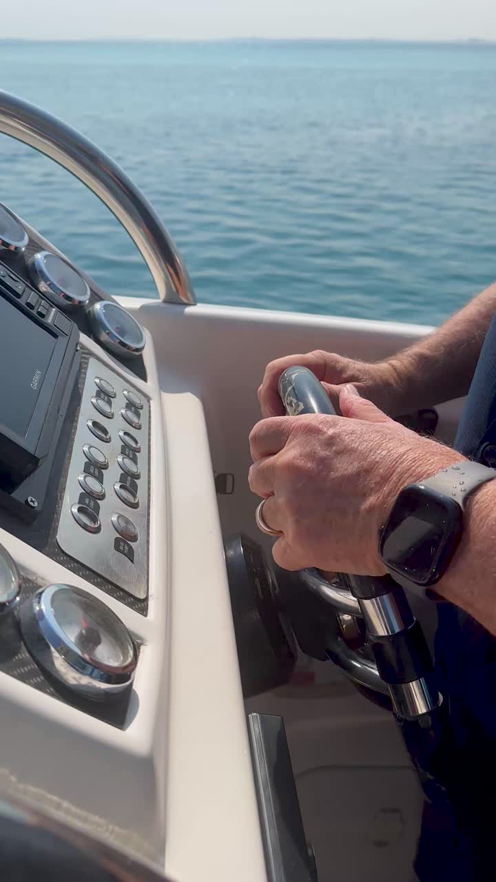 Capitano caucasico su uno yacht che governa la rotta e naviga in mare aperto, scatto verticale