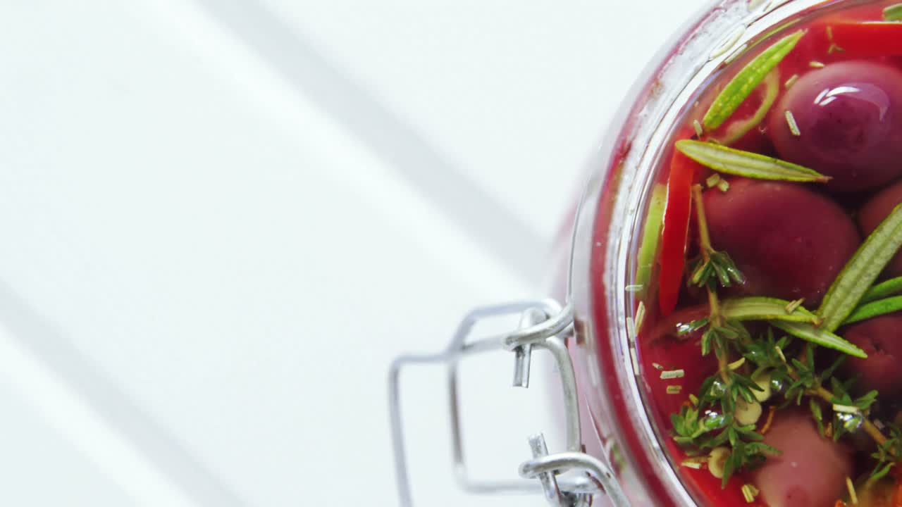 Pickled olives and herbs in a jar