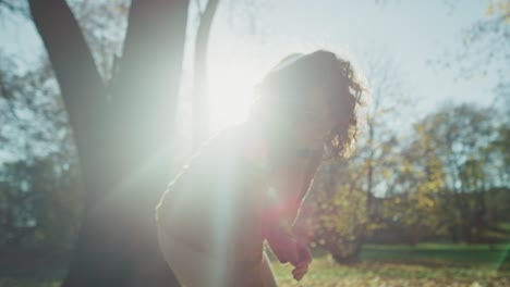 una mujer caucásica roja vomita hojas de otoño y disfruta del tiempo.