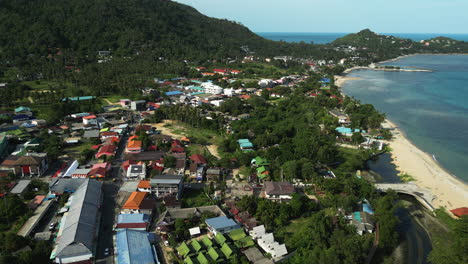 aerial flight over maret city on koh samui district beside sandy beach and ocean in summer, thailand