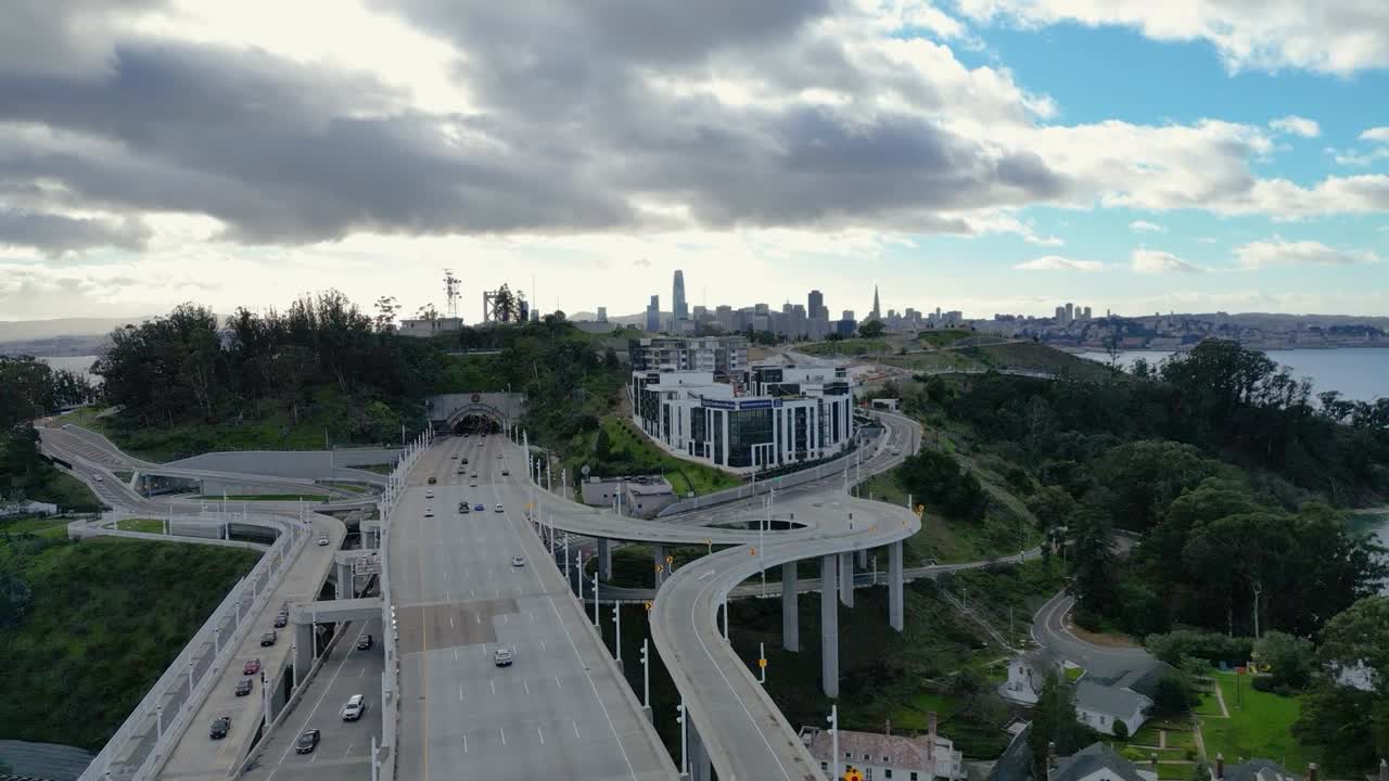 A dynamic side-tracking drone shot of the Bay Bridge from Yerba Buena Island, CA. The footage highlights the bridge, water, and surrounding urban landscape, ideal for travel and infrastructure themes.