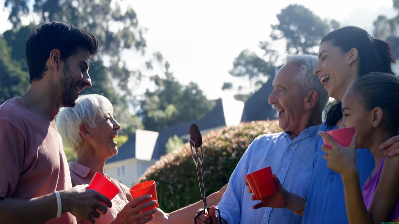 공원에서 바베큐를 준비하는 동안 웃고 이야기하는 가족 4k