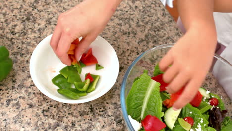 Mother-and-daughter-preparing-salad-together-