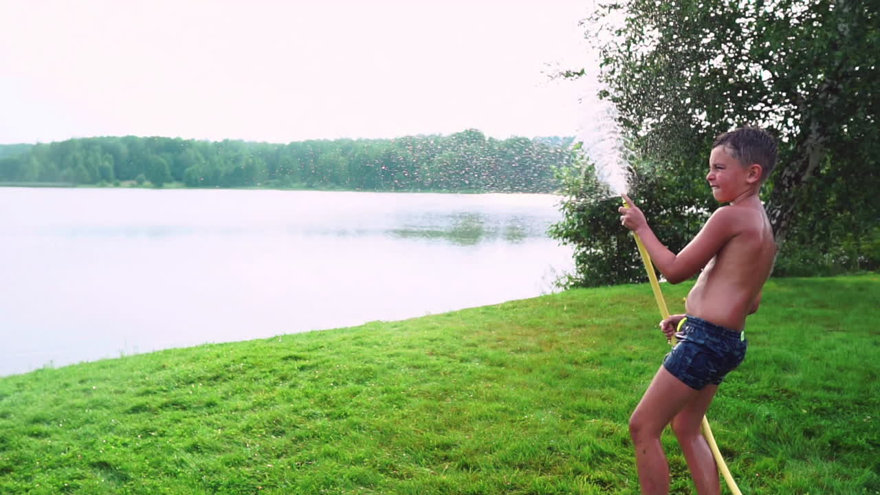 여름에 시골 집의 뒷마당에서 가족들이 물과 호스링으로 놀면서 휴식을 취합니다.