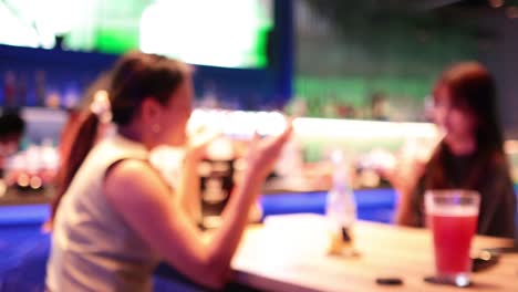 two women sharing drinks and conversation at bar