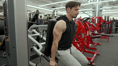 mature man in 40s doing lower chest muscles exercise in dips machine at modern health club