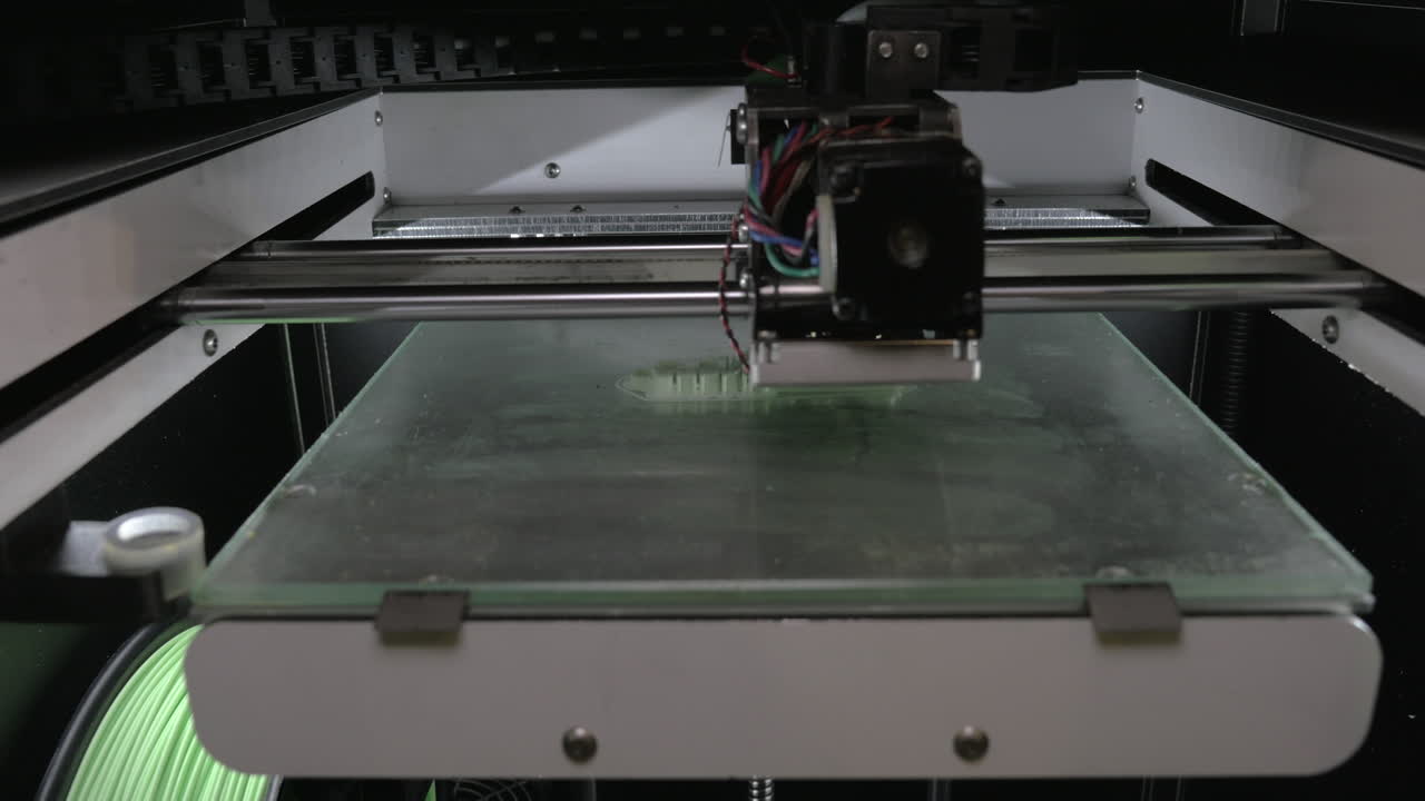 Vista aproximada do mecanismo de uma impressora 3D produzindo um objeto de plástico branco.