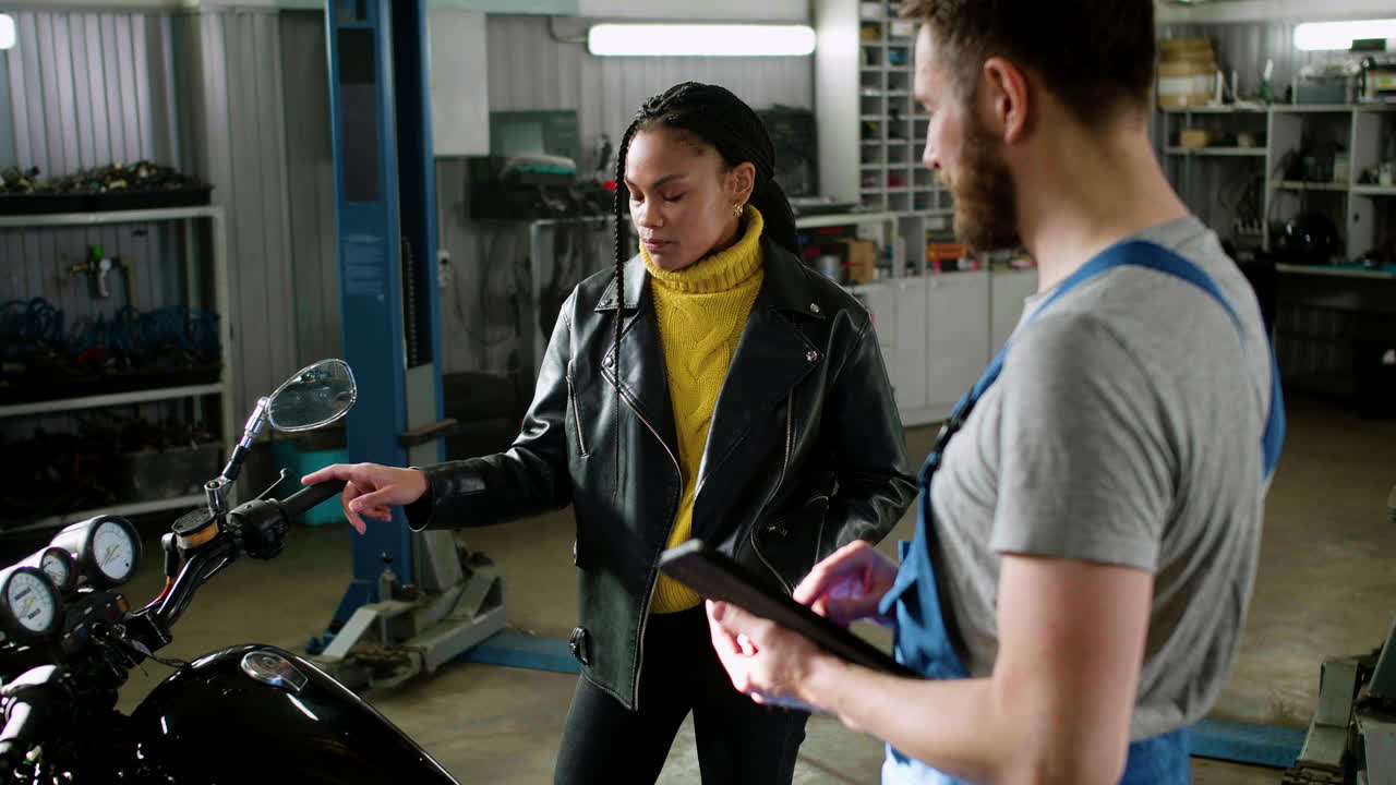 기계공과 라이더가 차고에서 대화하고 있습니다.