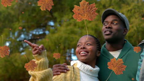 animation of autumn leaves falling over african american parents with son in park