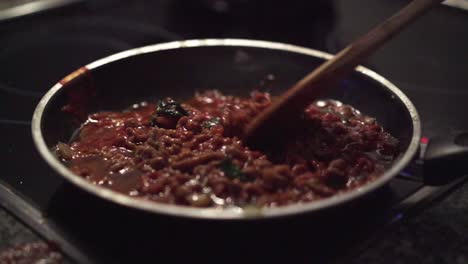 la carne picada en una sartén se mezcla con una cuchara de madera y luego se deja reposar