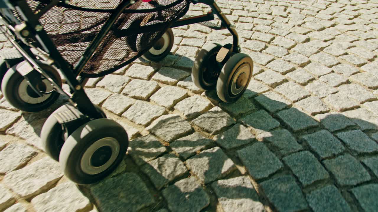 ruedas de un cochecito rodando en un camino de adoquines