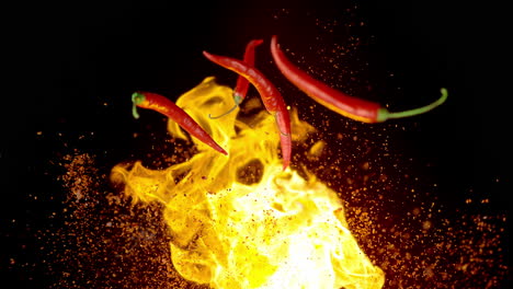 chili peppers and chipotle flakes rise up in an exploding fire, scatter and fall in slow motion