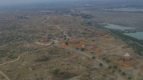 Aerial-rotating-shot-over-the-Tomb-Of-Dewan-Shurfa-Khan-on-Makli-Hill-in-rural-countryside-in-Thatta-,-Pakistan-at-sunset