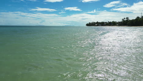 Fast-low-aerial-over-the-ocean-towards-Haad-Rin,-Ko-Pha-Ngan-Island,-Thailand