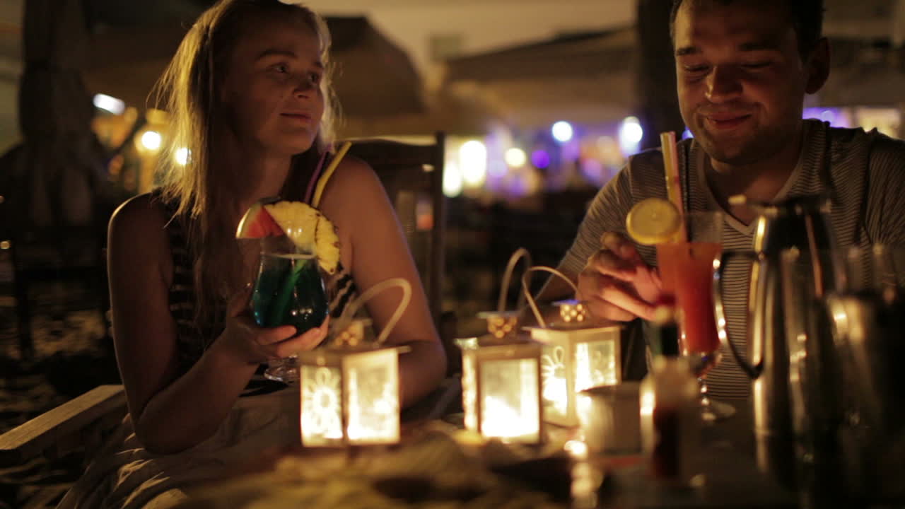 Casal jovem romântico desfrutando de bebidas em um encontro.