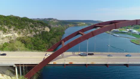 minor traffic moving from left to right on the pennybacker bridge with a view of the city of austin, texas in the upper right hand corner