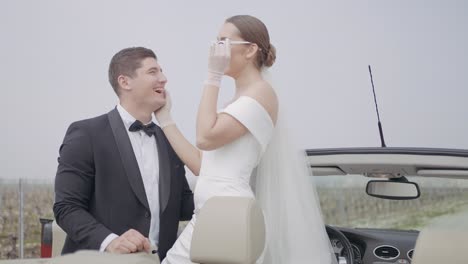 romantic wedding couple in convertible car