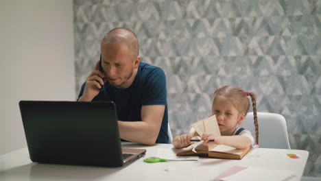 young daughter do homework, sits at table with book