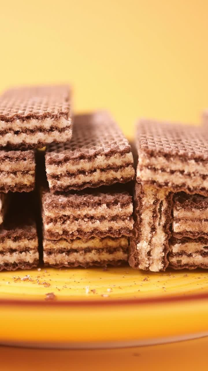 Biscotti wafer al cioccolato impilati su un piatto giallo