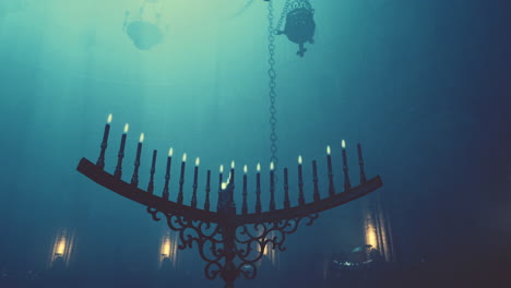 a gothic chandelier with lit candles hanging in a dark, shadowy church