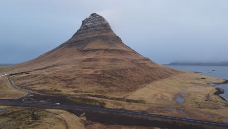 aerial shot of a car passing on kirkjufell road in iceland