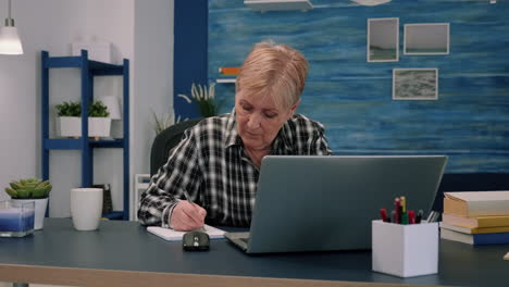 serious mature middle aged business woman using laptop typing email