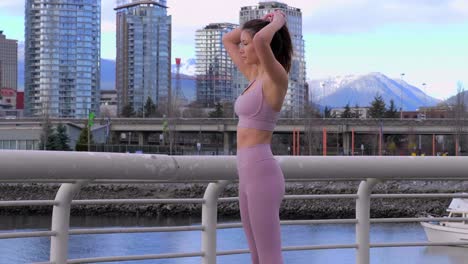 sporty asian model poses and fixes hair with vancouver bc building cityscape