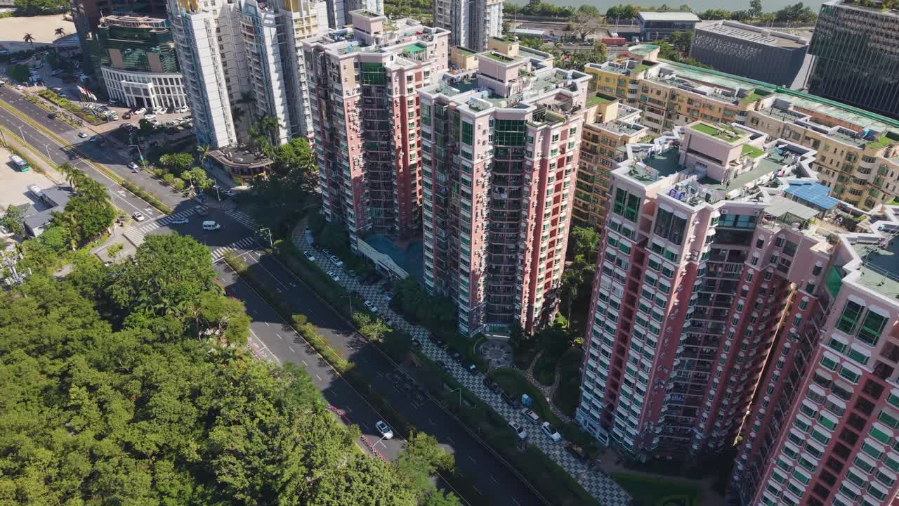 Aerial of a modern residential area in Shenzhen, China, showcasing high-rise apartment buildings and surrounding greenery. Ideal for real estate, urban development, and lifestyle footage. UHD
