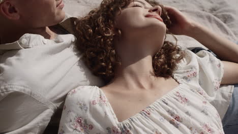 relaxed girl lying boyfriend chest relaxing on beach close up. couple sunbathing