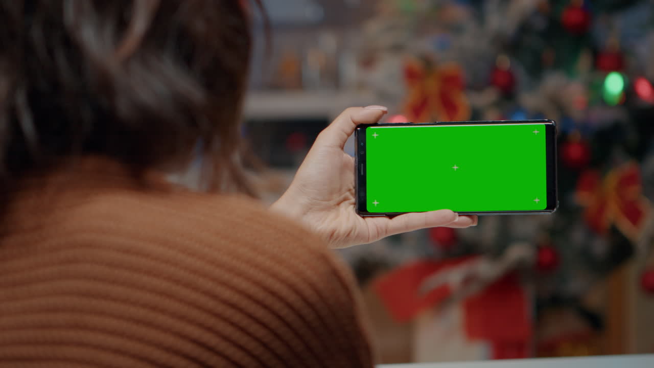 joven usando un teléfono inteligente de pantalla verde