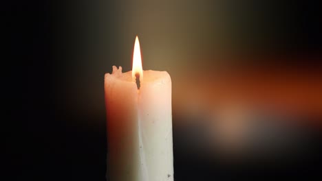 the showcases of colorful single candlelight on black background with the effect of light and slow motion