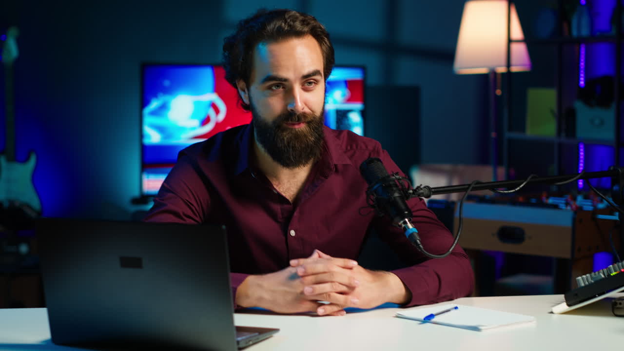 hombre en un estudio casero iluminado con neón usando equipo para disparar vlogs,