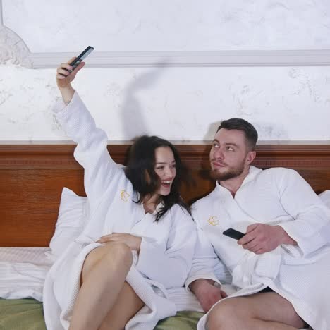 couple in bedroom of hotel. happy couple with bathrobes in bedroom