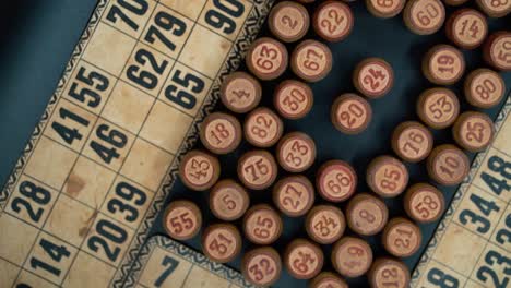 cinematic close-up smooth shot from above of a pile of bingo wooden barrels in a square, woody figures, old numbers background, vintage board game, slow motion 120 fps commercial rotating gimbal video