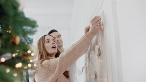 casal feliz decorando sala de estar com guirlandas de ano novo juntos