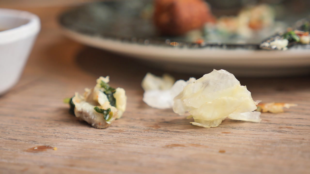 Food Scraps and Dirty Plate on a Wooden Table After a Meal