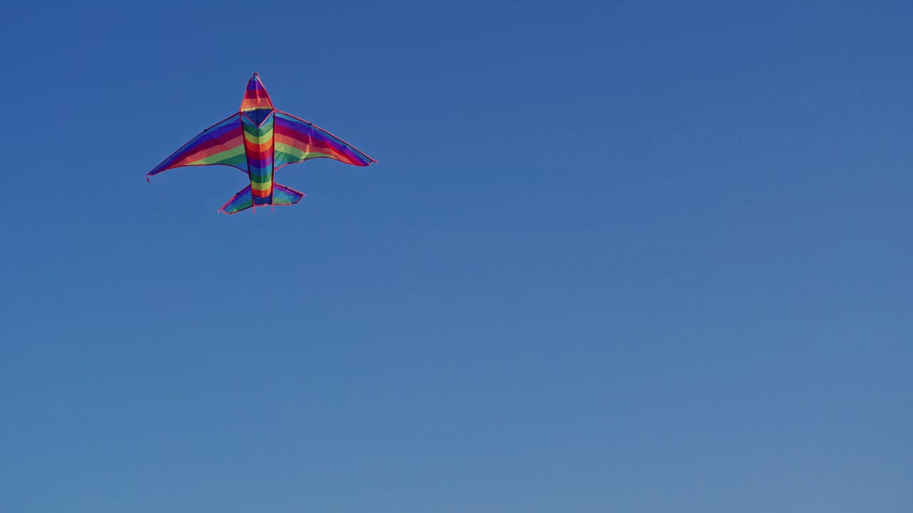 Kite flying against blue sky. View of a colorful kite flying with waving in a deep blue sky