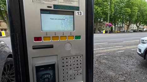 person retrieves ticket from parking machine