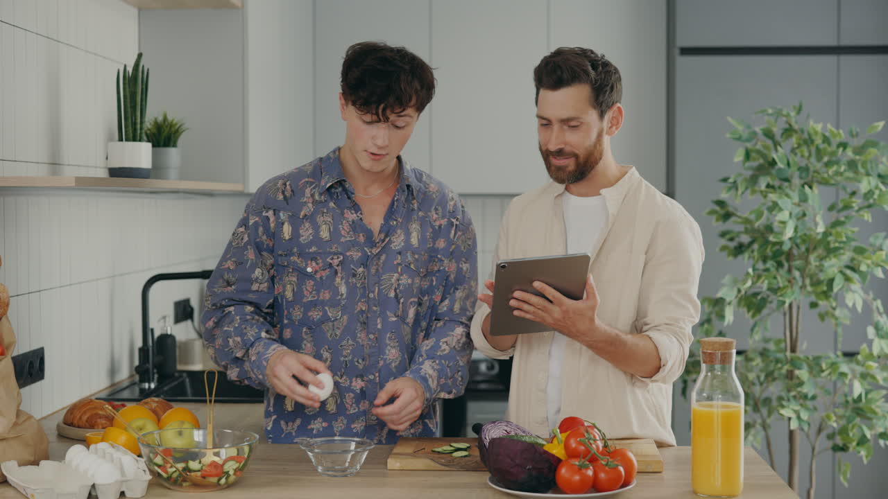 Men Preparing a Salad Together in a Kitchen