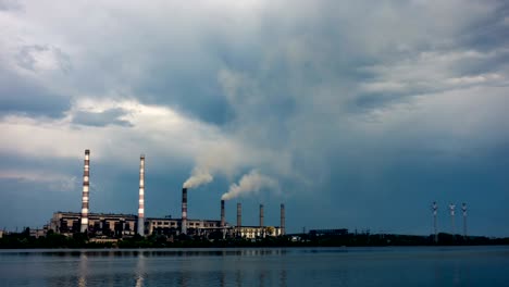 smoke from the pipes of power plant station at the bank of a river