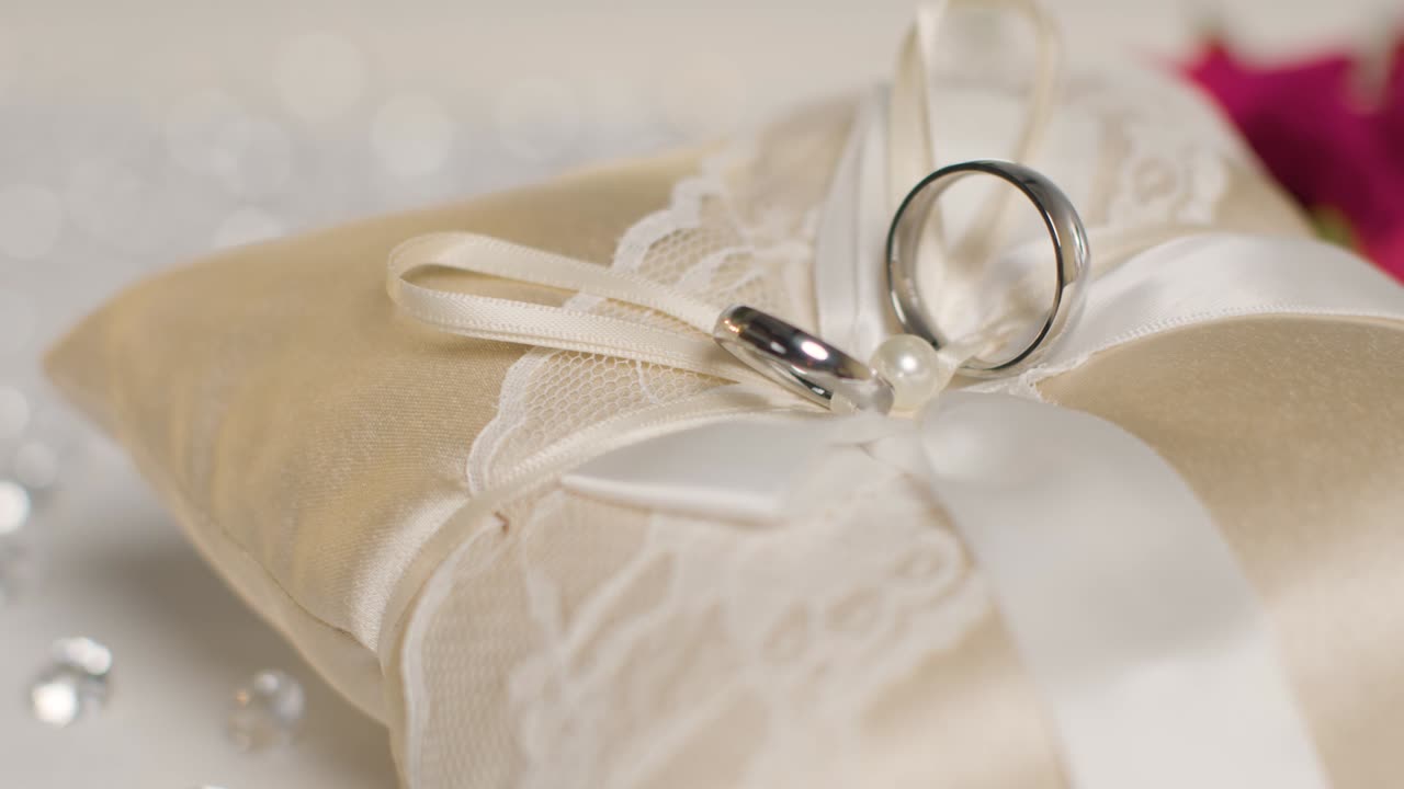 близкое изображение обручальных колец для невесты и жениха на небольшой украшенной подушке 2